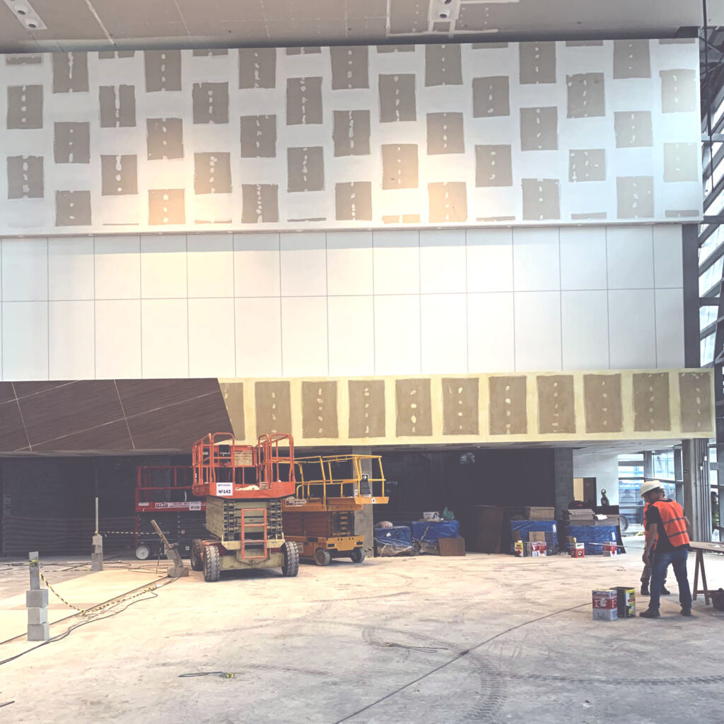 parede em drywall em processo de instalação em ambiente de pé direito alto
