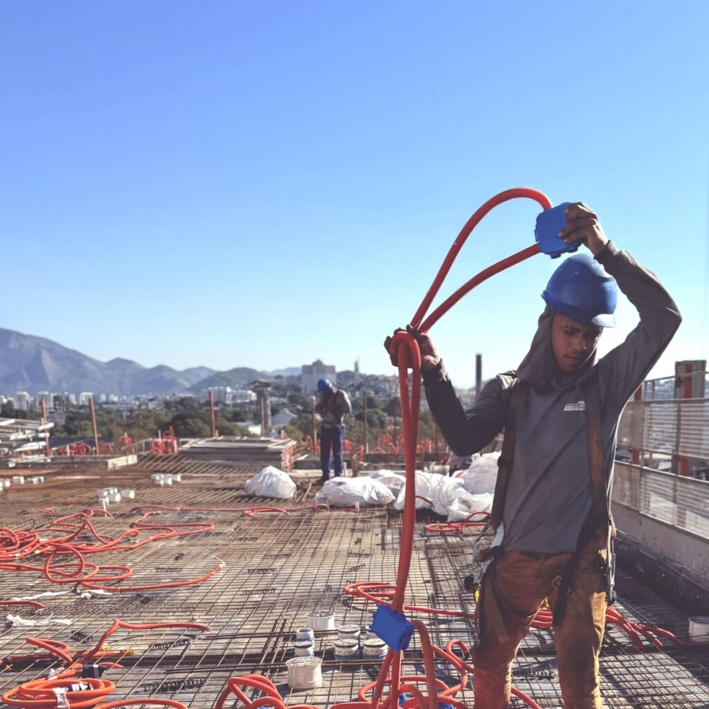 Trabalhador instalando conduítes elétricos